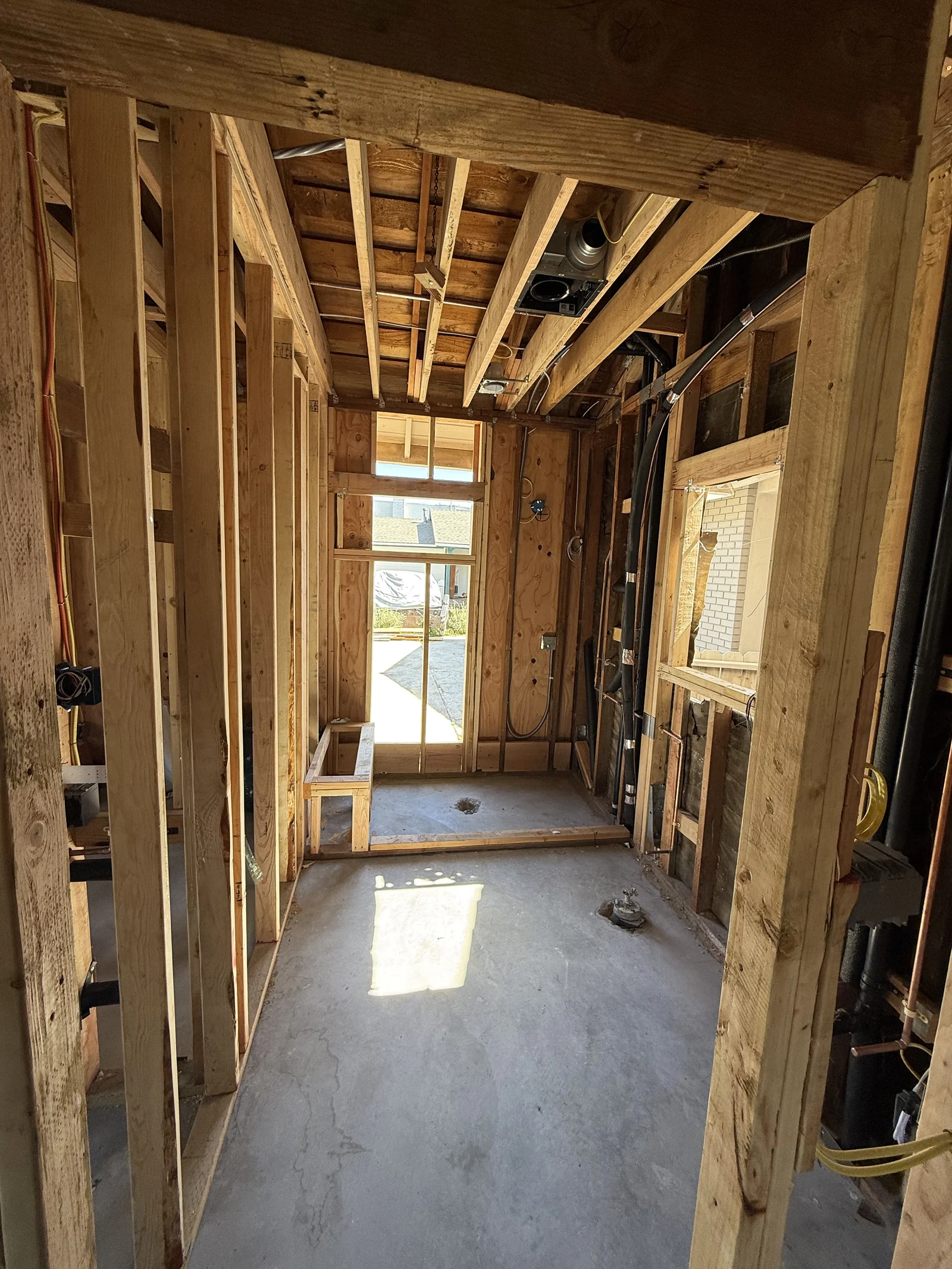 Exposed timber framing, a window opening and ceiling components inside the space during the work.
