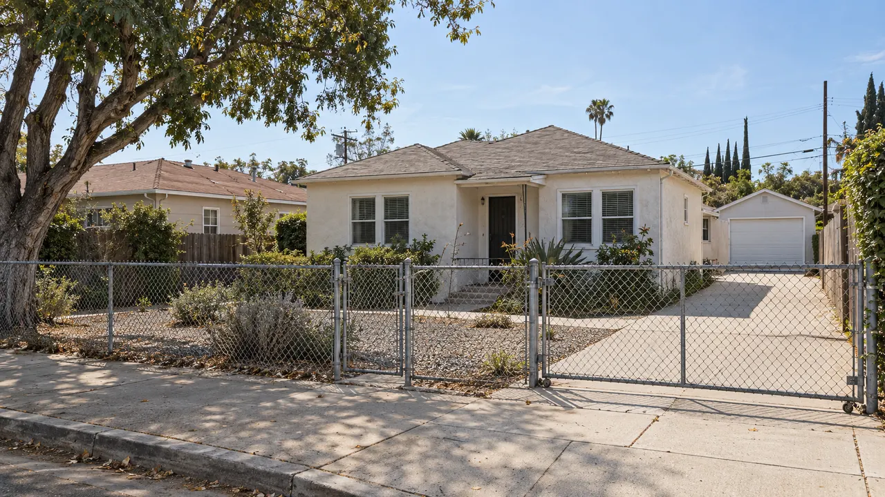 a modest Southern California property edge with an ordinary worn low fence and a simple approach.